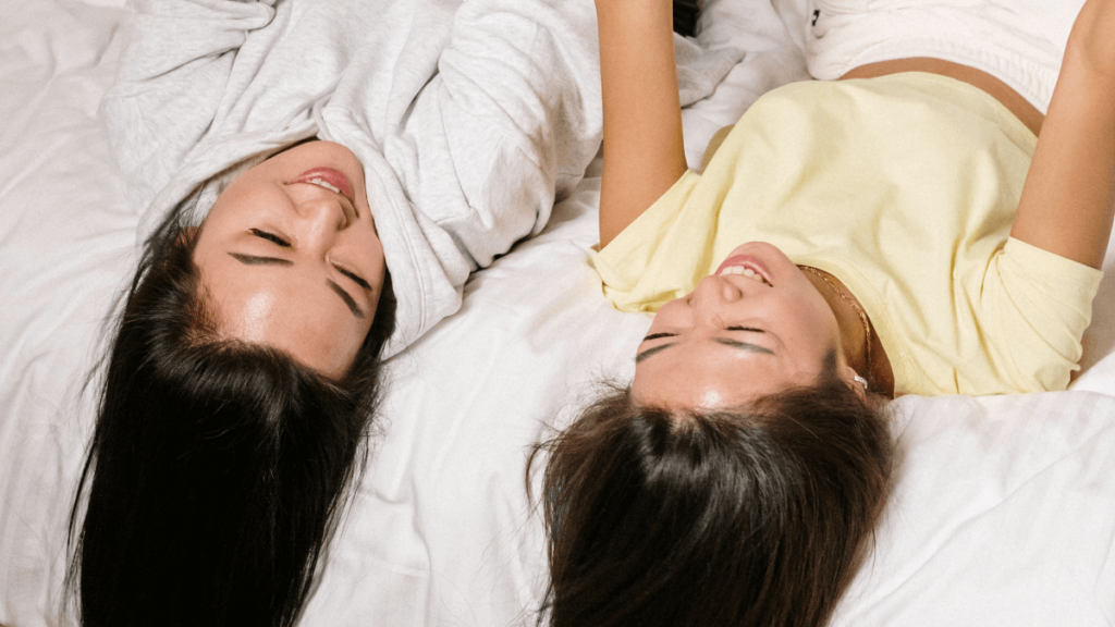 Two women laughing on a bed